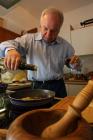 Duilio Belić gießt das Olivenöl in die Pfanne