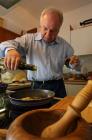 Duilio Belić gießt das Olivenöl in die Pfanne